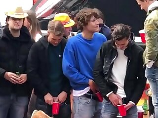 Young guys pee into cups while on a boat